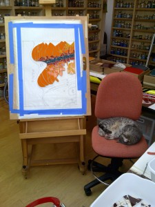 cat asleep in a mosaic studio next to a mosaic work-in-progress