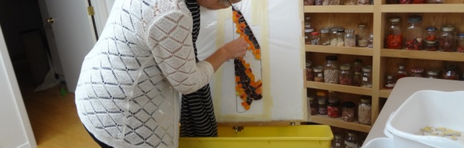 Lynn Bridge checking a mosaic project in her art studio